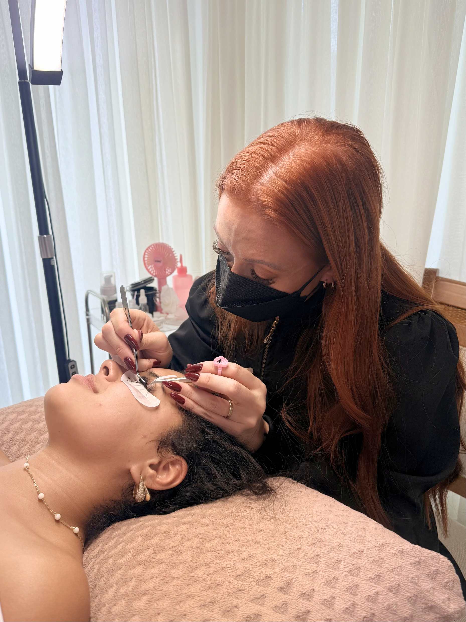 Cinthia Ribeiro realizando extensão de cílios com precisão e cuidado